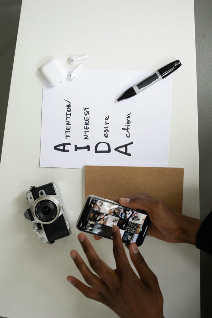 Flat lay of camera, smartphone, and AIDA marketing text on a desk.